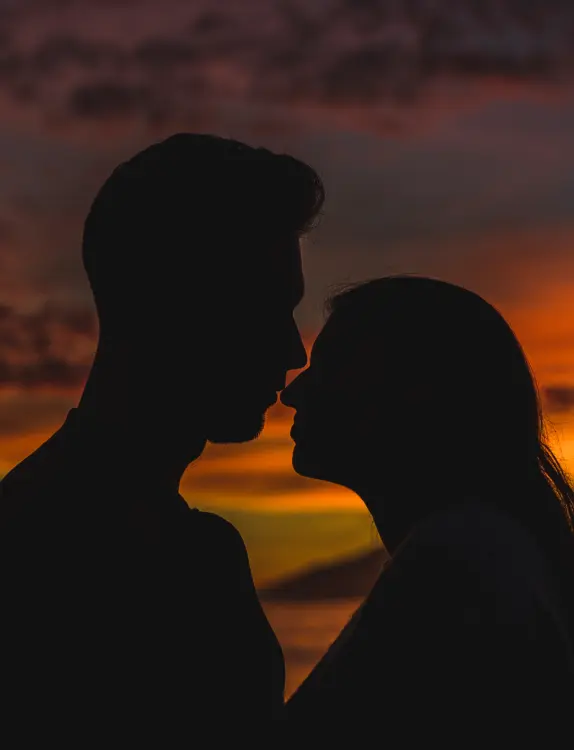 Young couple standing on sea shore in night